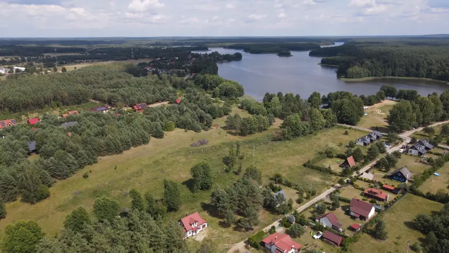 Panorama jeziora w pobliżu domków Kwiat Jabłonki, otoczonego lasem
